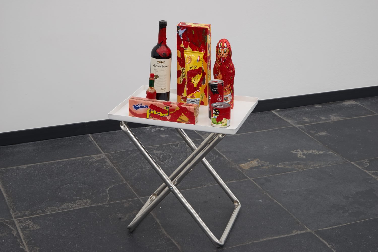 Anna-Sophie BergerComplicit 1Acrylic paint on &quot;heritage release&quot; red wine bottle, chocolate bananas, mayonaise, chocolate krampus, coke zero, manner fredi biskuits, tabasco, PVC, aluminium and polyester70 x 46 x 36 cmArs Viva, S.M.A.K., Ghent, 2018
